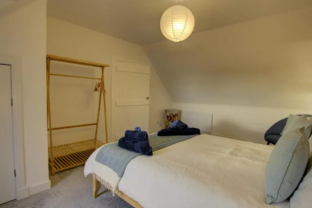 a bedroom with a large bed and a mirror at Tigh-na-Mara, Helmsdale in Helmsdale