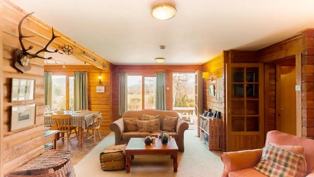 a living room with a couch and a table at Balbeag Cottage in Insh