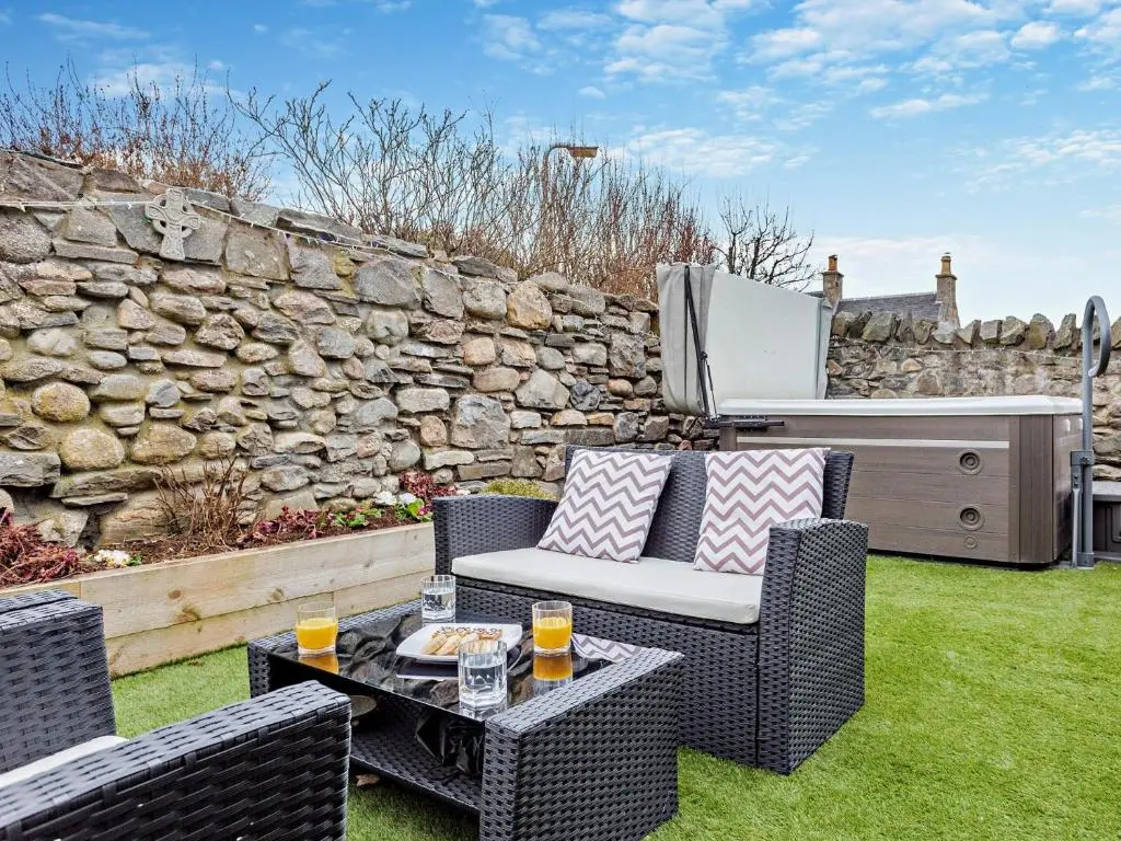 a patio with two chairs and a table with drinks at 3 Bed in Grantown-on-Spey 94514 in Grantown on Spey