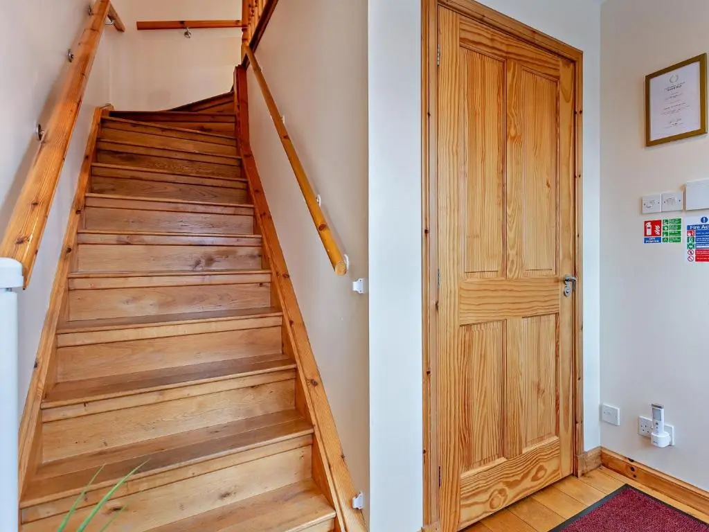 a staircase with a wooden door in a room at 3 Bed in Grantown-on-Spey 94514 in Grantown on Spey