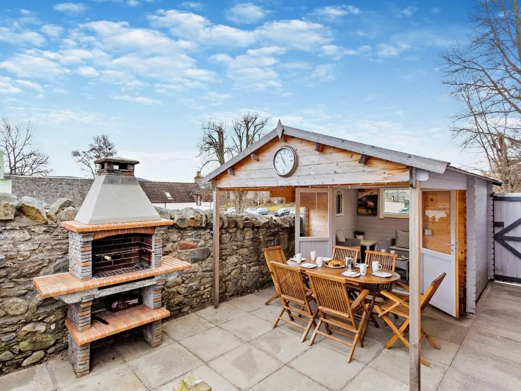 a small house with a table and a fireplace at 3 Bed in Grantown-on-Spey 94514 in Grantown on Spey