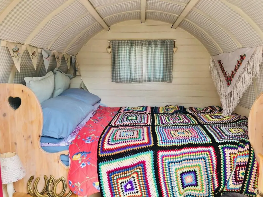 a bedroom with a bed in the middle of a room at Bowtop Wagon at Lettoch Farm in Keith