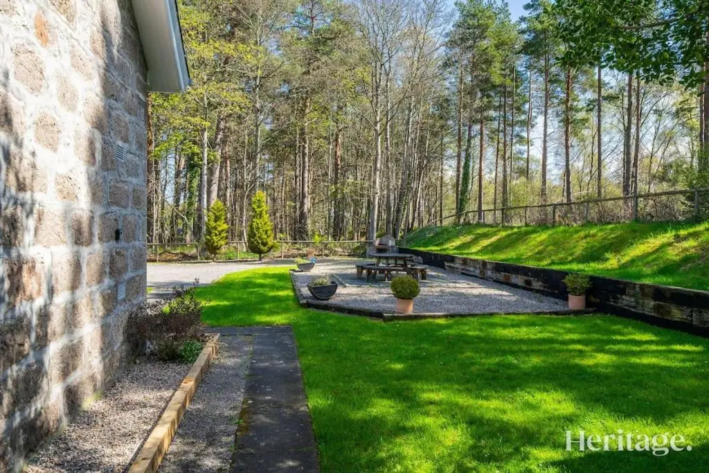a park with benches and grass and trees at Station Cottage Dinnet, Aboyne in Aboyne