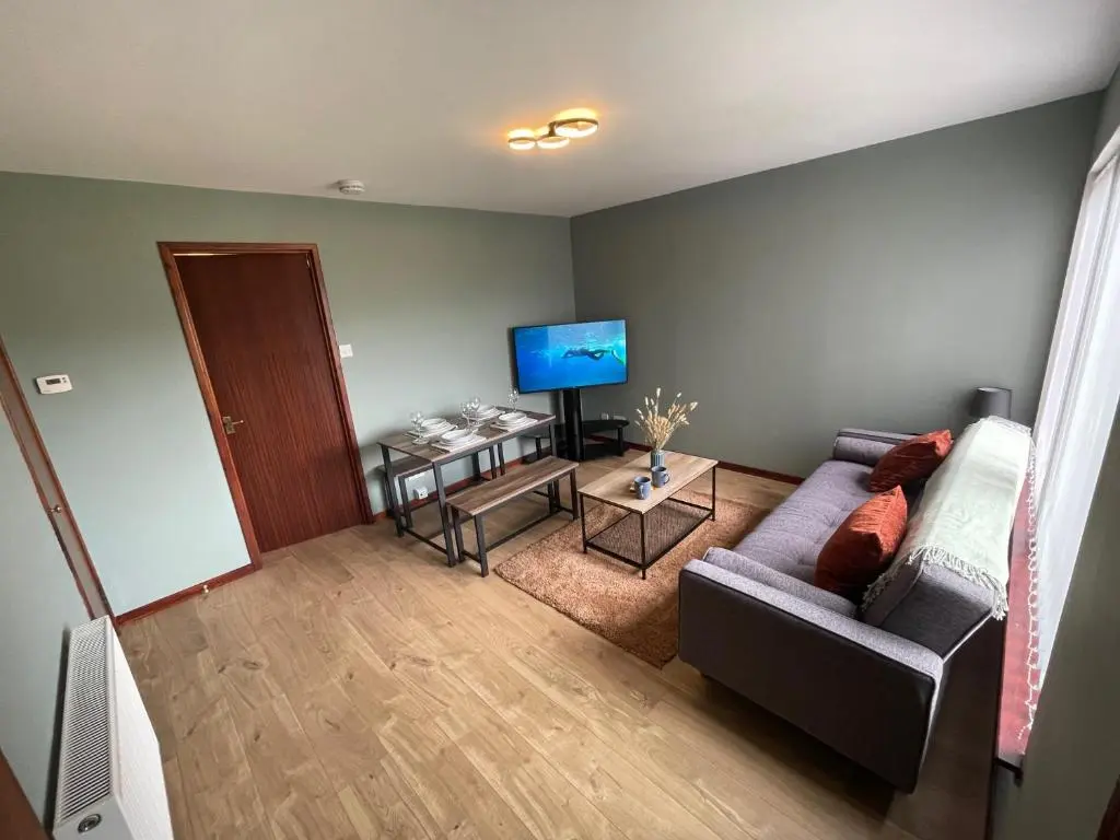a living room with a couch and a television at Meggies Place in Inverness