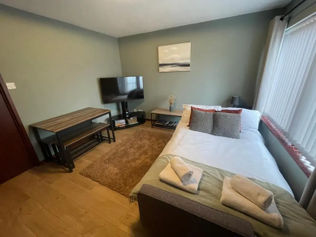 a bedroom with a bed with pillows and a television at Meggies Place in Inverness