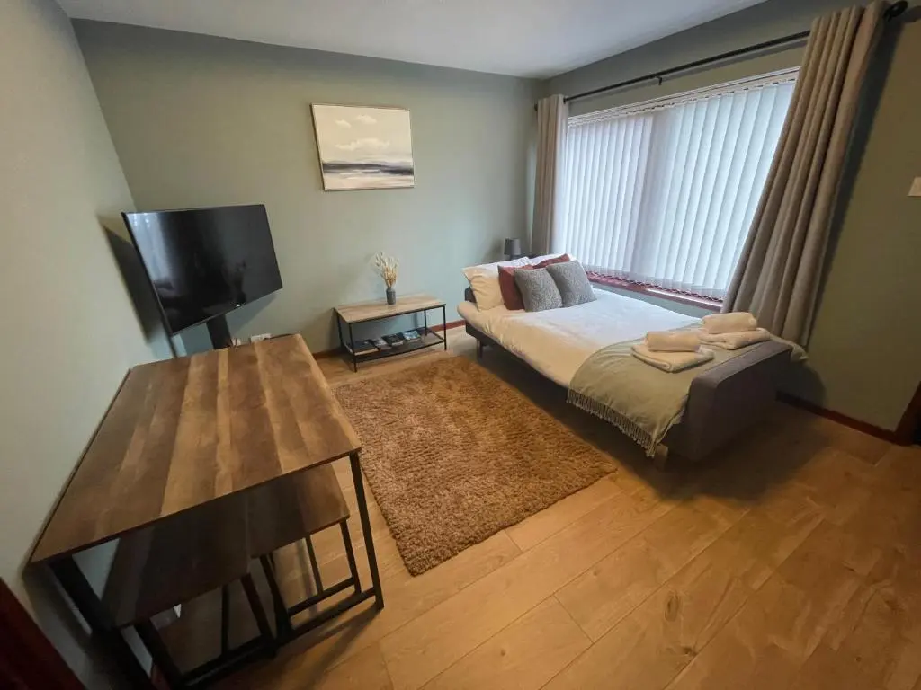 a small bedroom with a bed and a television at Meggies Place in Inverness