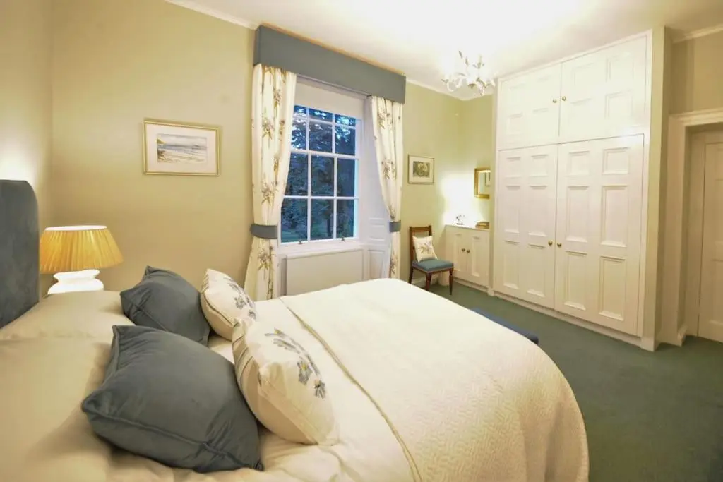 a bedroom with a bed with pillows and a window at Cray House - Large Country Home in Perthshire in Cray
