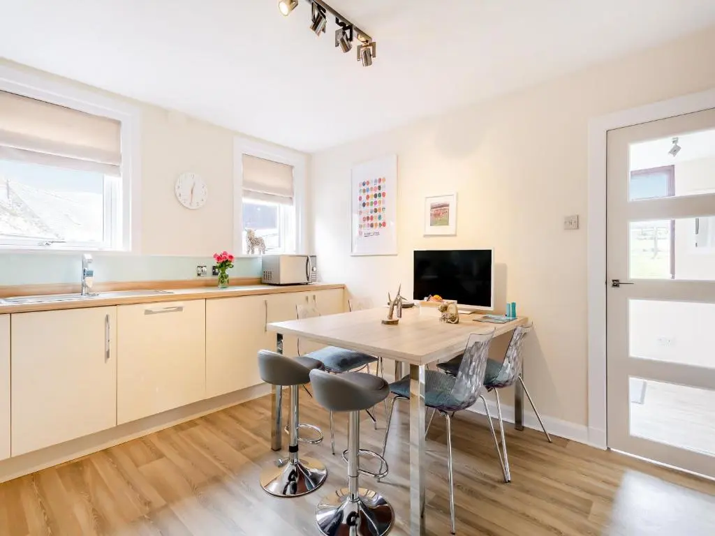 a kitchen and dining room with a table and chairs at Mid Bellandy in Ballindalloch