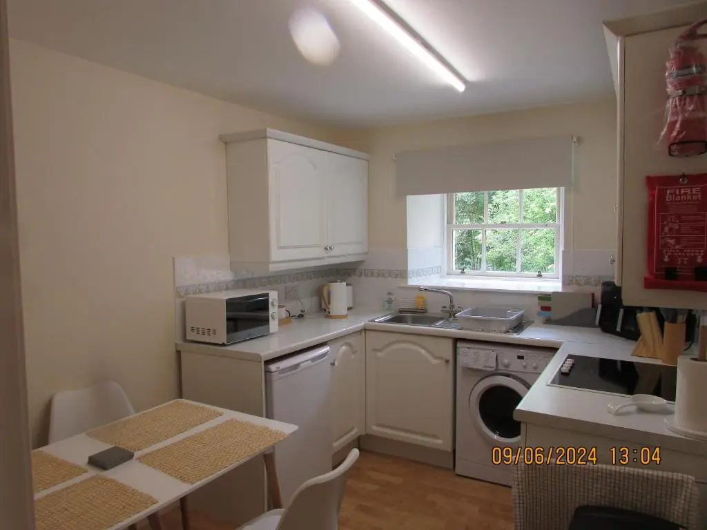 a kitchen with a sink and a washing machine at Culloden Stables 4 in Inverness