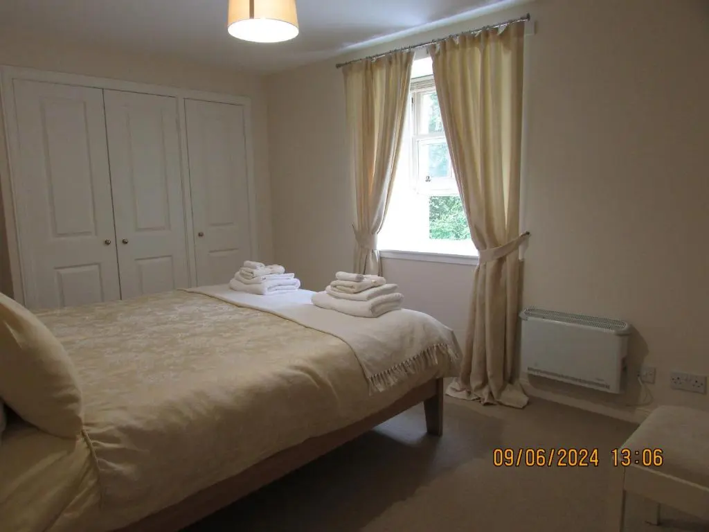 a bedroom with a bed and a window at Culloden Stables 4 in Inverness
