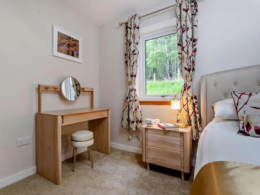 a bedroom with a bed and a desk and a window at 2 Bed in Kiltarlity 95056 in Kiltarlty