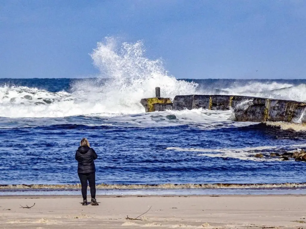 a woman standing on the beach watching the waves at Apartment Harbour Nights 4 by Interhome in Lossiemouth
