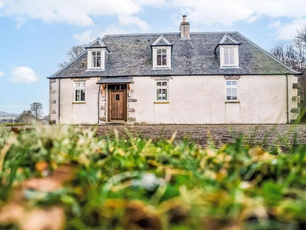 a large white house with a wooden door at Holiday Home Old Stables by Interhome in Drumnadrochit