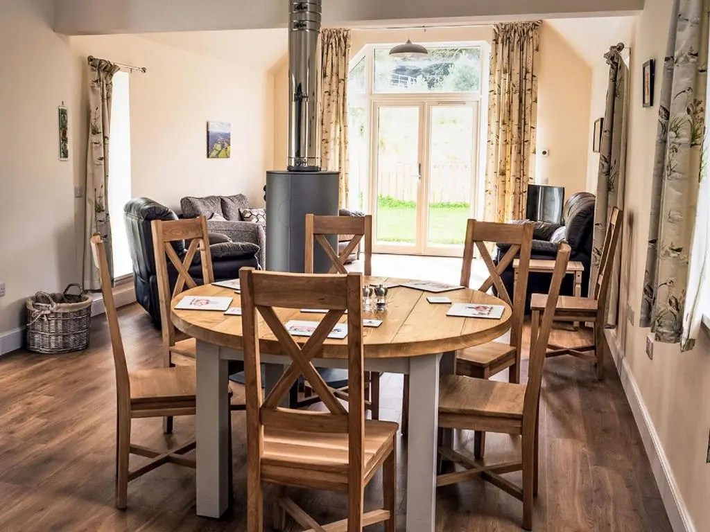 a dining room and living room with a table and chairs at Holiday Home The Barn by Interhome in Drumnadrochit