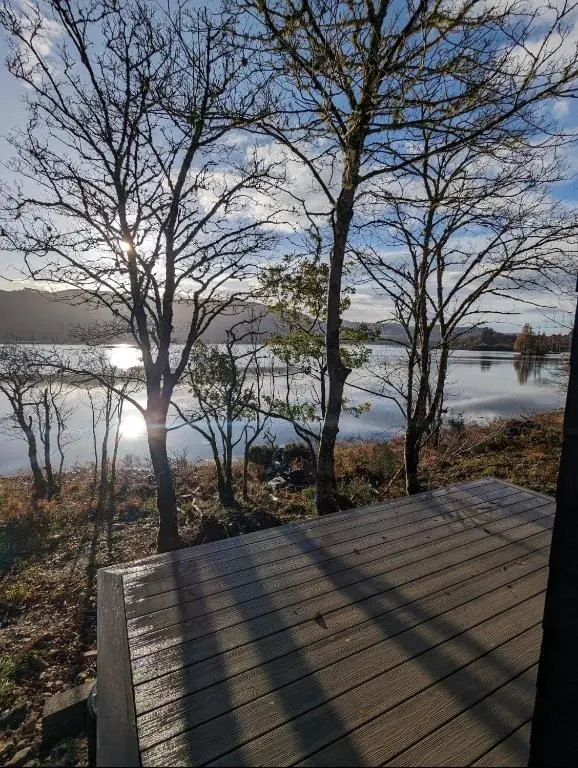 a wooden deck with a view of a lake at Alba Pod in Fort Augustus