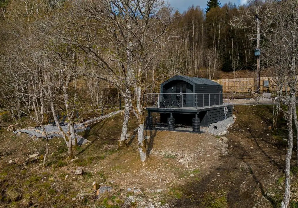 an overhead view of a black building in the woods at Alba Pod in Fort Augustus