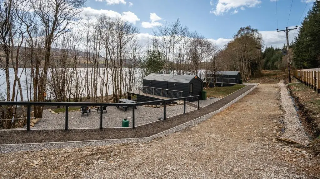 a fence in front of a body of water at Alba Pod in Fort Augustus