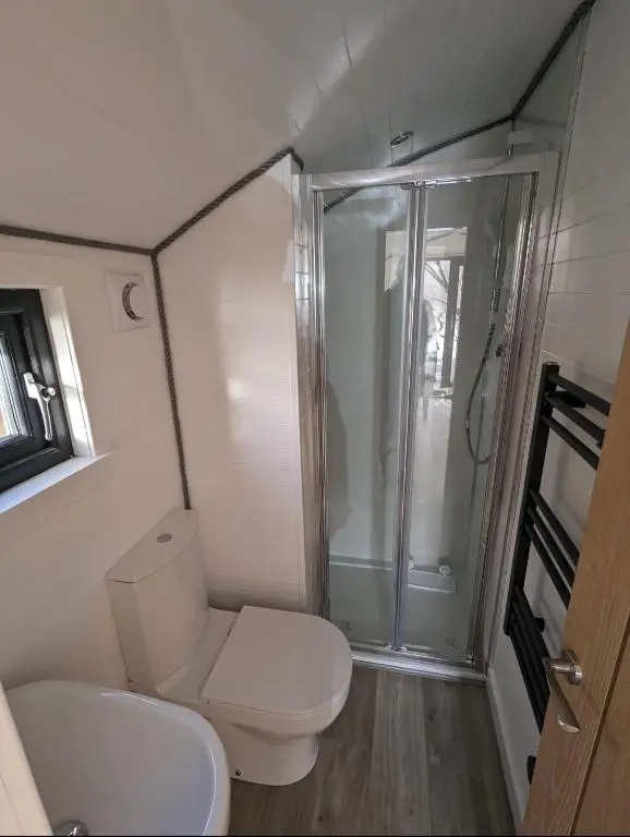 a small bathroom with a toilet and a shower at Alba Pod in Fort Augustus
