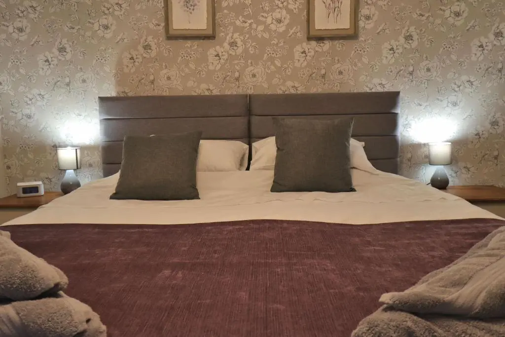 a bedroom with a large bed with two lamps at Fisherman's Rest in Helmsdale
