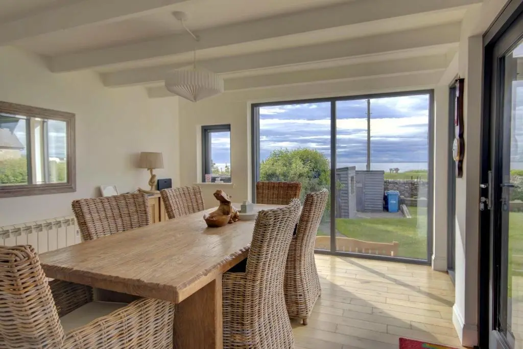 a dining room with a wooden table and chairs at Wilsons, Golspie in Golspie