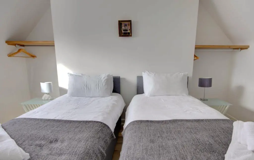 two beds sitting next to each other in a room at Wilsons, Golspie in Golspie