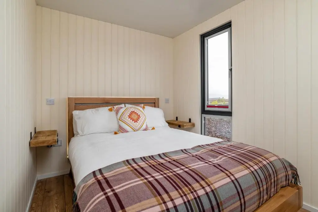 a bedroom with a bed and a window at The Off Grid Cabin in Insch