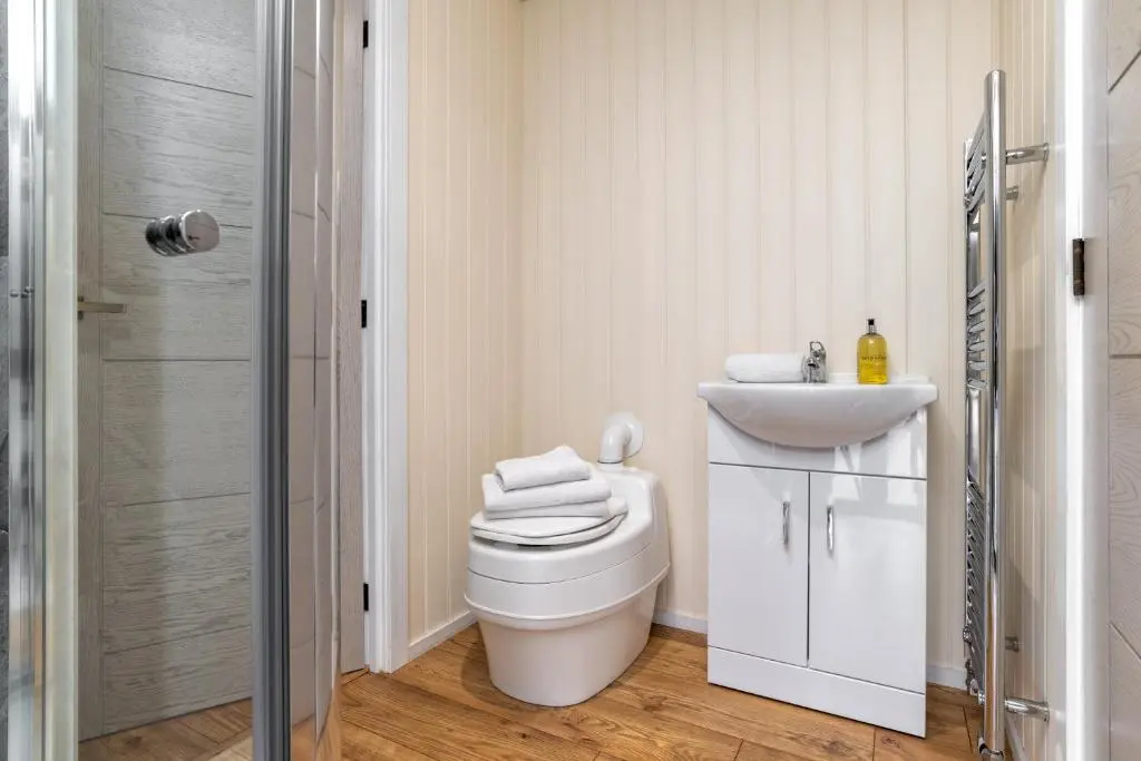 a bathroom with a toilet and a sink at The Off Grid Cabin in Insch