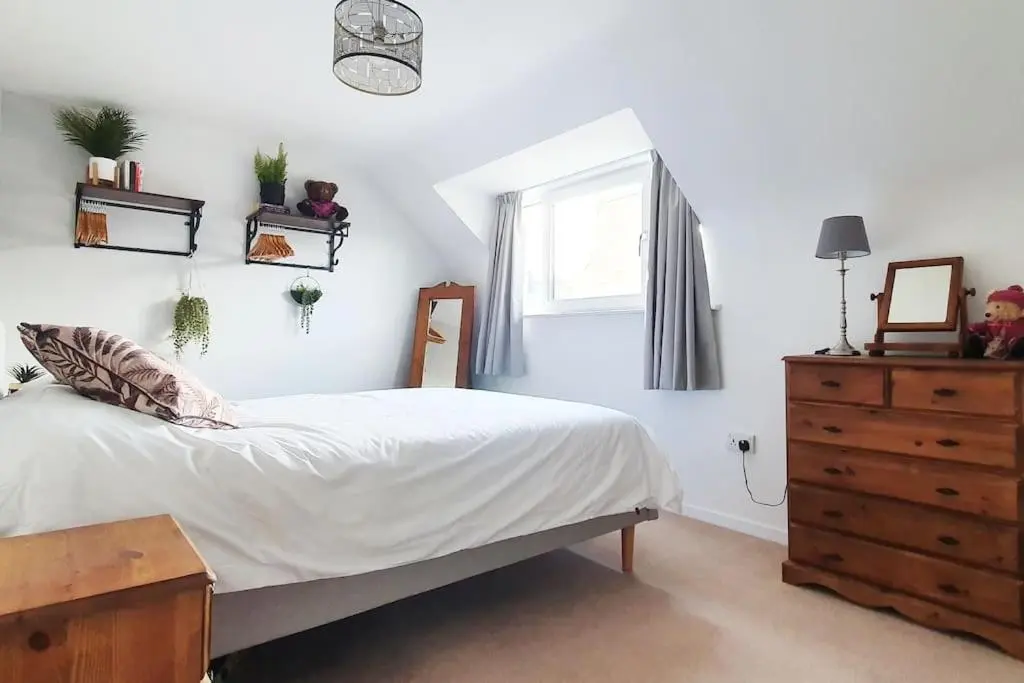 a bedroom with a bed and a dresser and a window at York Street Retreat, modern cosy 2 bed with garden in Dufftown