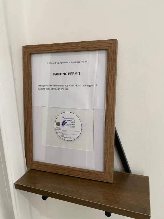 a picture in a wooden frame on a shelf at 39 Wells Street Apartment in Inverness