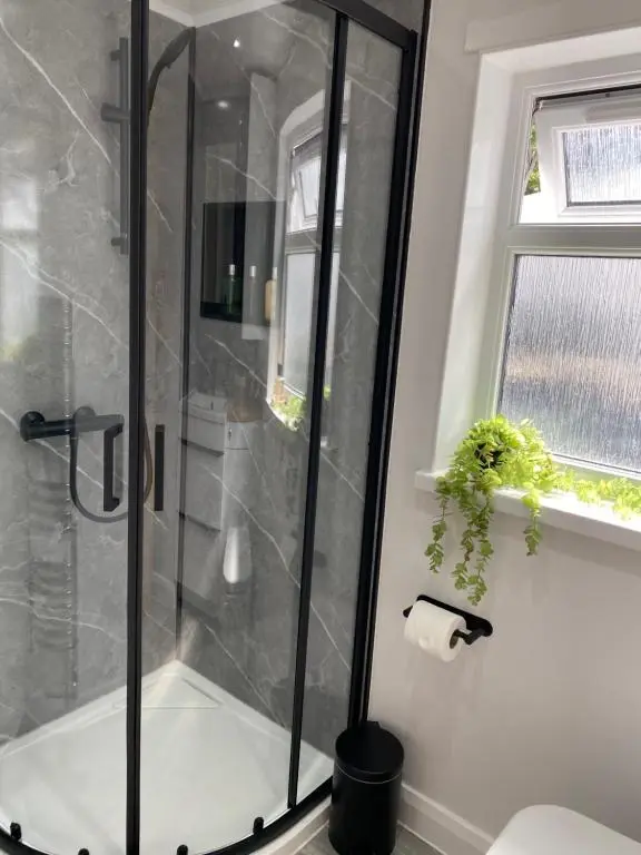 a shower with a glass door in a bathroom at 39 Wells Street Apartment in Inverness