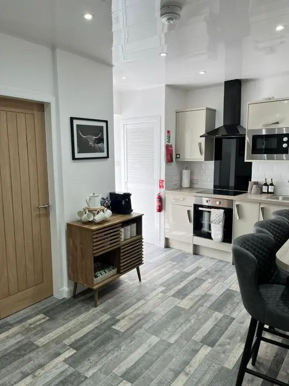 a kitchen with white walls and a wooden table in a room at 39 Wells Street Apartment in Inverness