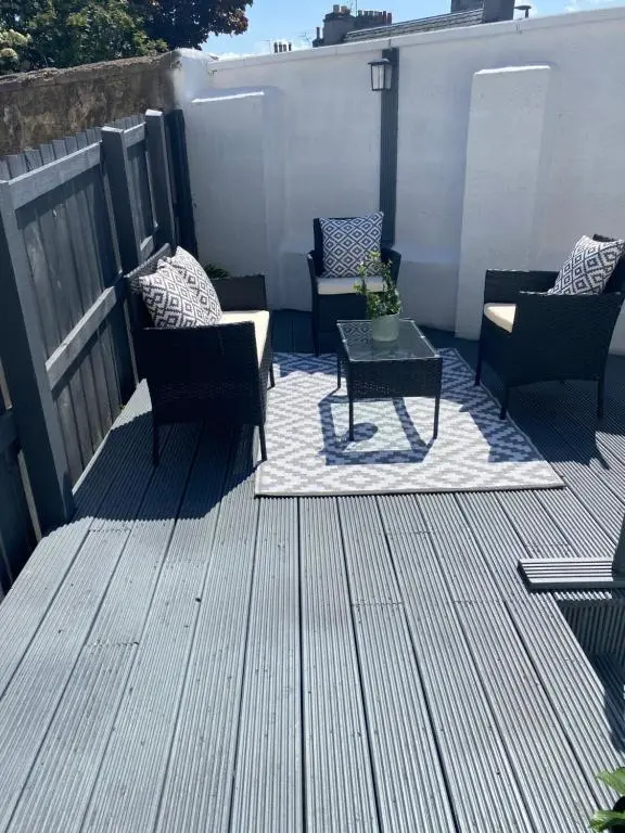 a patio with chairs and a table on a deck at 39 Wells Street Apartment in Inverness