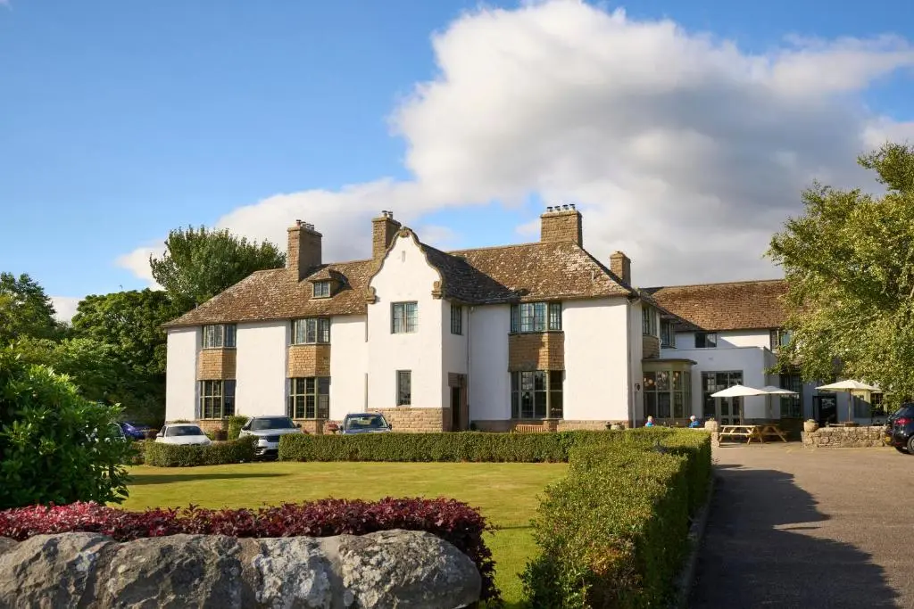 a large white house with a yard at Royal Marine Hotel, by Highland Coast Hotels in Brora