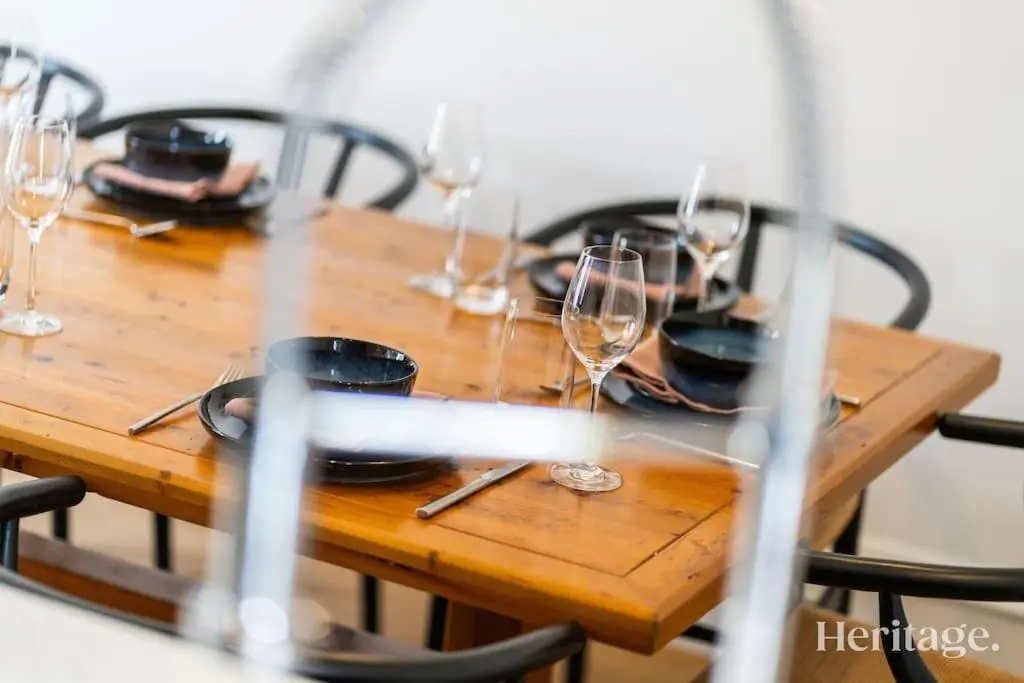 a wooden table with wine glasses and plates on it at Kirkton Family Farmhouse with Hot Tub, Alford, Aberdeenshire in Alford