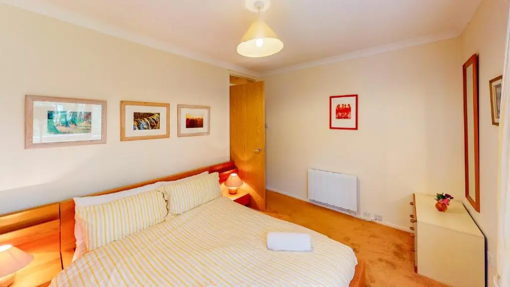 a small bedroom with a bed and a tv at Torr Beatha in Kincraig