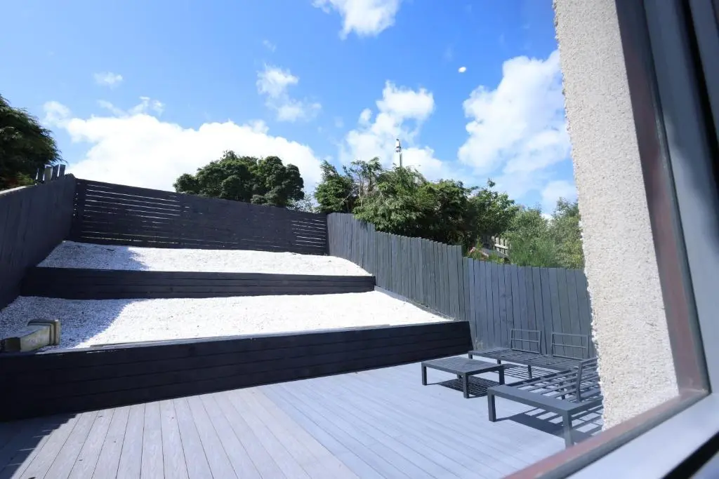 a patio with two benches and a fence at Stylish Highland Home in South Kessock