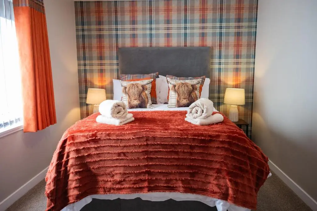 a bedroom with two towels on a bed at North Coast Cottage - Coastal Highland Retreat with Sea Views in Portgower