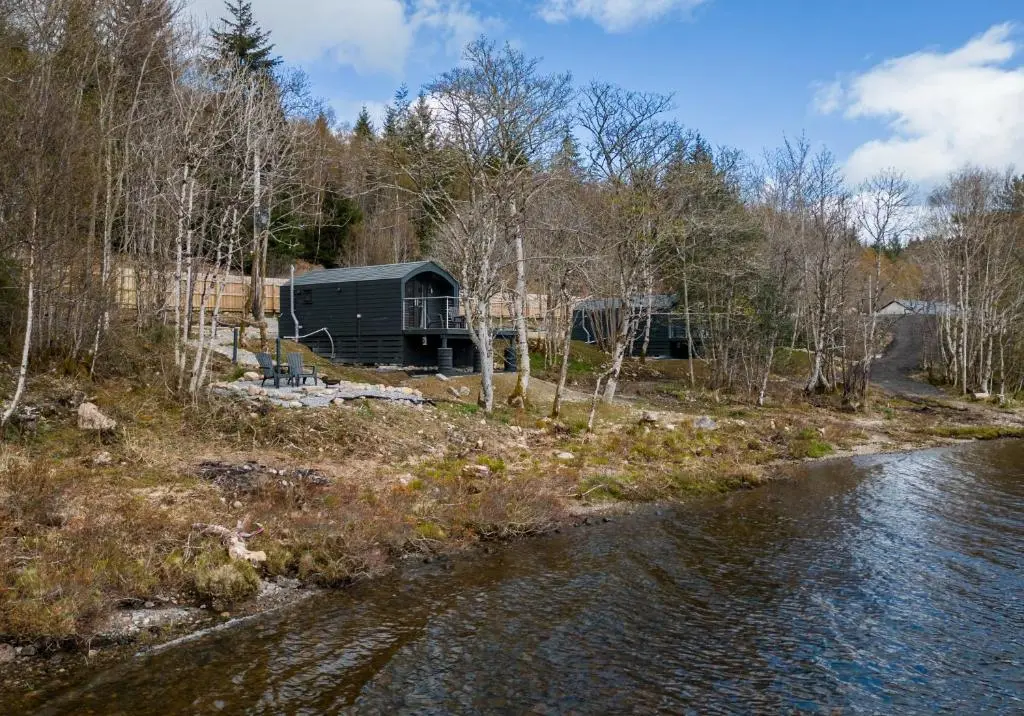 a view of a cabin next to a river at Nessie Pod in Fort Augustus