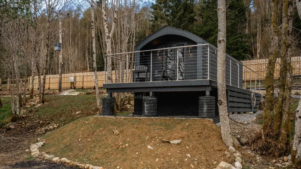 a building in the middle of a forest at Nessie Pod in Fort Augustus