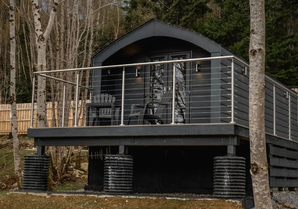 a tree house with a black exterior at Nessie Pod in Fort Augustus