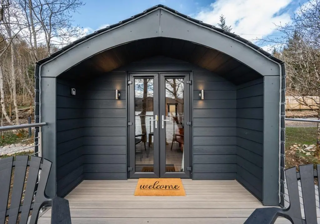 a black shed with the door open on a deck at Nessie Pod in Fort Augustus