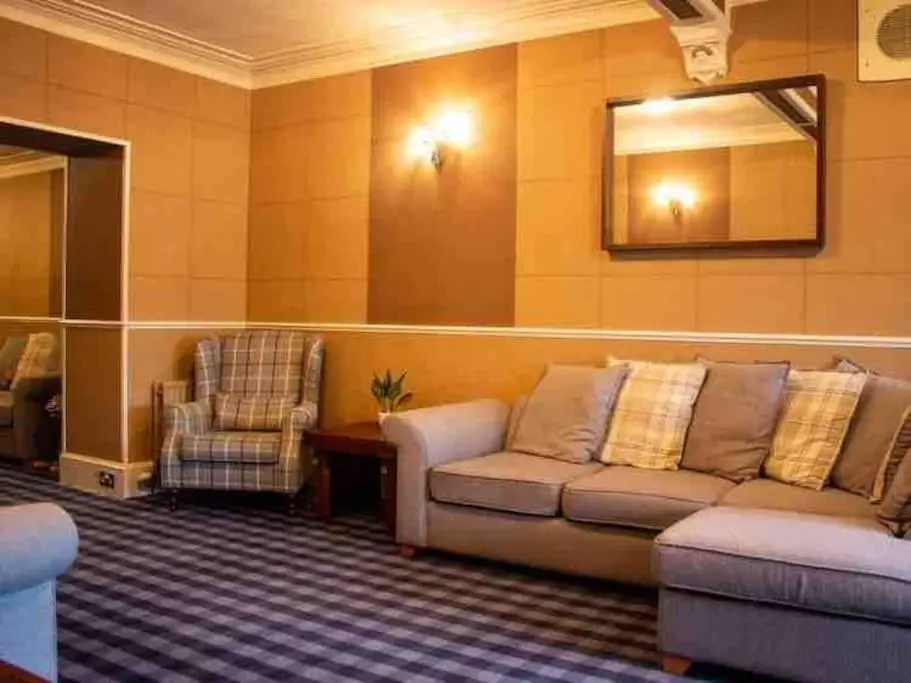 a living room with a couch and a chair at Crannoch Self Catering - 10 bedroom former hotel in Cullen