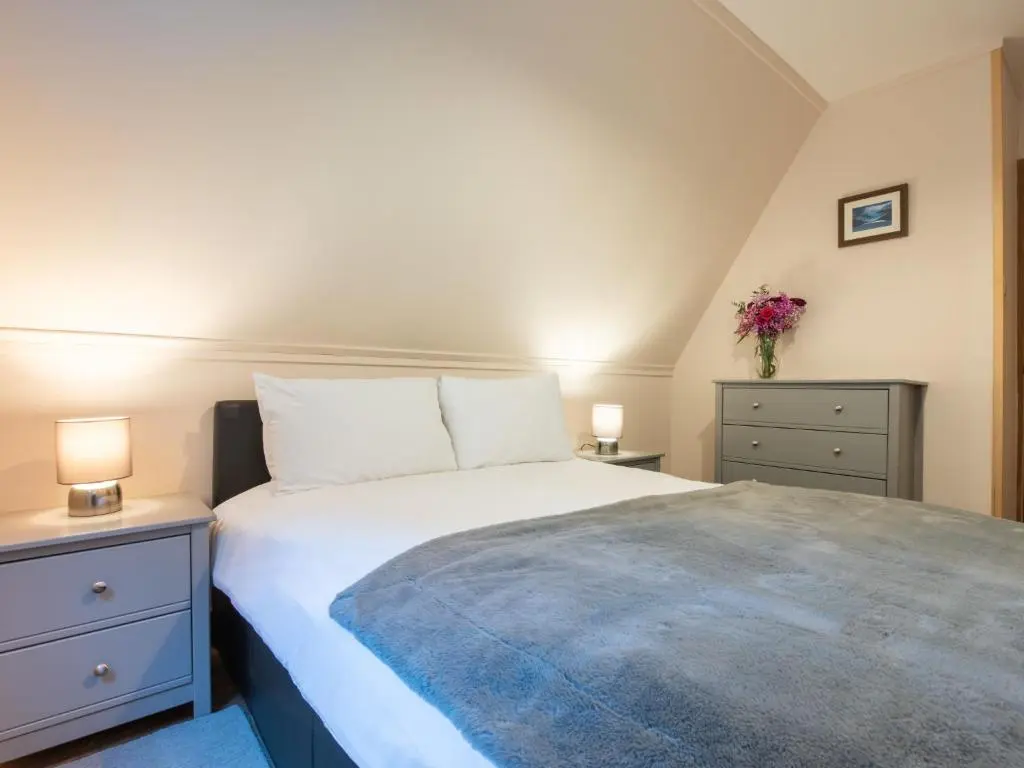 a bedroom with a bed with two night stands and two lamps at Chalet Loch Lochy Retreat by Interhome in Spean Bridge