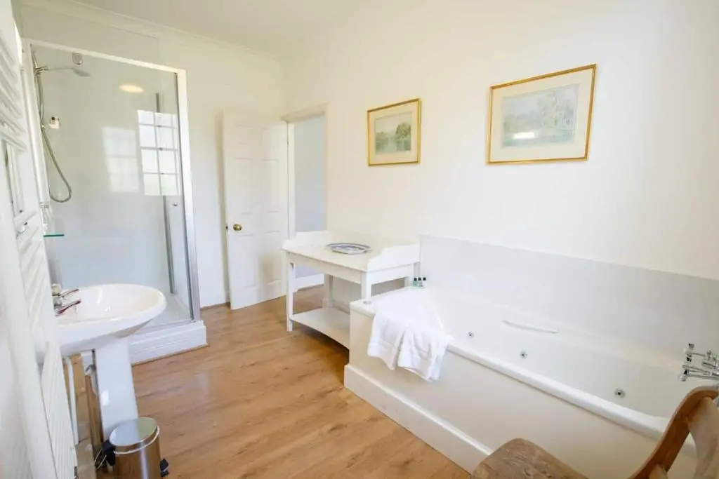 a white bathroom with a tub and a sink at Little Fyrish in Evanton