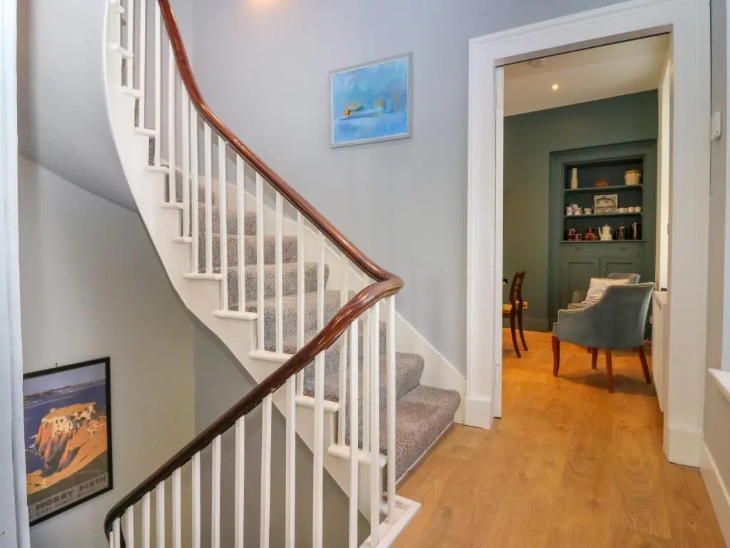 a staircase with white railings in a home at 1A Carmelite Street in Banff