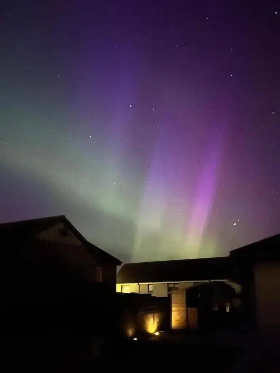 an aurora in the sky over a building at Wee Coastal Snug in Wick