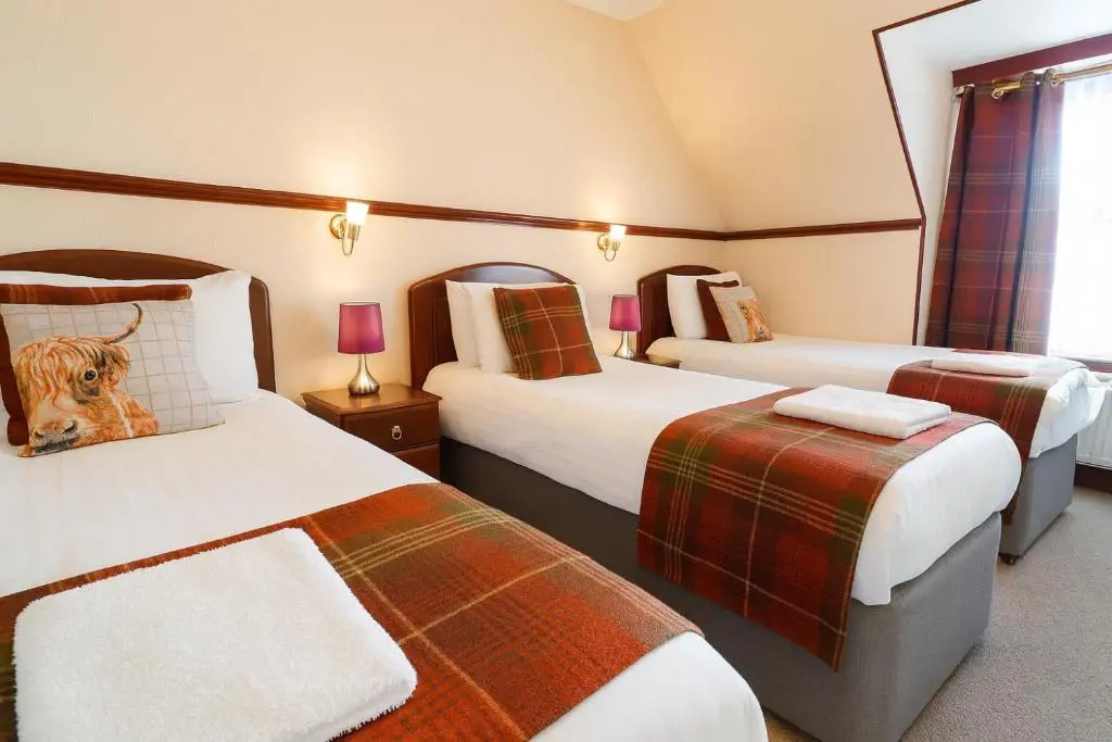 a hotel room with two beds and a dog pillow at Tanera in Inverness