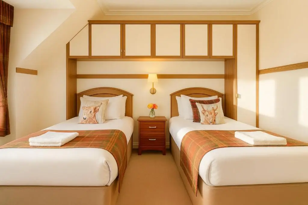 two beds in a hotel room with two beds sidx sidx sidx at Tanera in Inverness