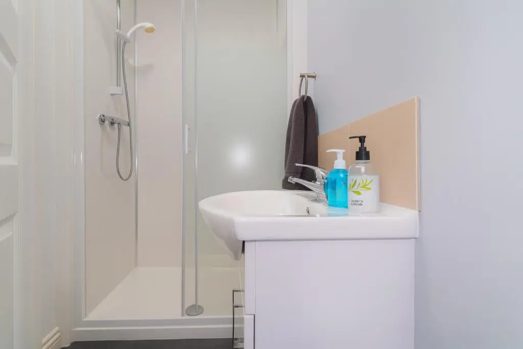 a white bathroom with a sink and a shower at Tanera in Inverness