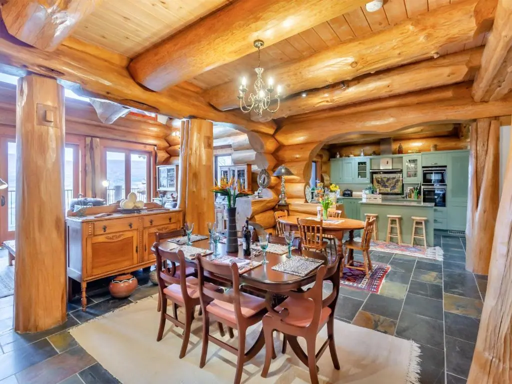 a kitchen and dining room with wooden ceilings and a table and chairs at Molalatau Lodge in Lairg
